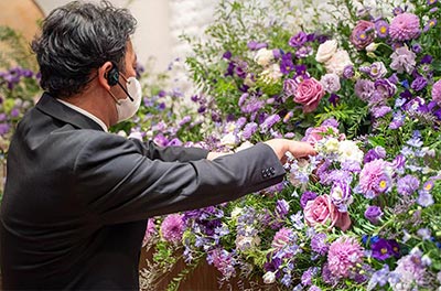 フラワリングセレモニーのスタッフが丁寧に祭壇のお花をアレンジしています