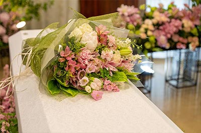 棺の上に美しくアレンジされた花束が置かれています